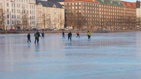 Amigos-Pasan-El-Día-Soleado-En-Helsinki-Jugando-Hockey-En-Una-Pista-De-Hielo-Al-Aire-Libre