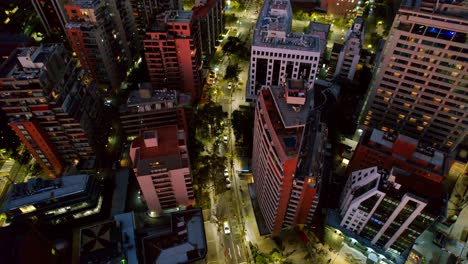 Aerial-night-view-of-cityscape-with-illuminated-streets-and-dense-urban-buildings