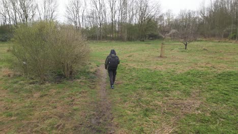 Siguiendo-Un-Sendero,-Un-Mochilero-Camina-Por-Un-Camping-Situado-En-La-Orilla-Del-Río-Leicester,-En-Las-Afueras-Del-Reino-Unido