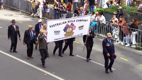 Representatives-from-Australian-Rifle-Company,-Communist-Insurgency-in-Malaysia-marching-down-the-street,-participating-annual-Anzac-Day-parade-tradition,-paying-tribute-to-war-heroes