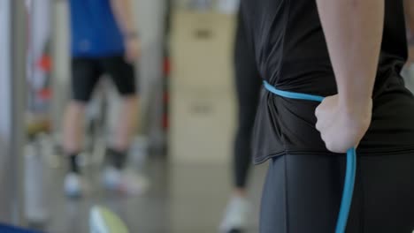 Close-up-shot-of-female-doing-exercises-with-rope-and-the-gym