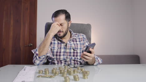 A-worried-man-doing-accounting-with-calculator-retires-his-glasses-and-holds-his-face