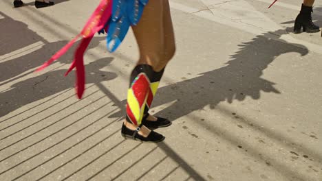 Mujer-Con-Traje-De-Loro-Colorido-Levanta-Alas-De-Plumas-Rojas-Amarillas-Azules-Bailando