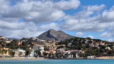 Timelapse-De-La-Playa-De-La-Malagueta-En-Un-Día-Soleado-Con-Una-Montaña-Al-Fondo-Y-Nubes-Que-Se-Mueven-Rápidamente