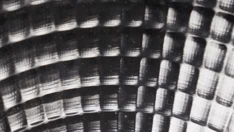 Close-up-of-a-textured-metal-surface-with-a-hypnotic-circular-pattern,-monochrome-tones