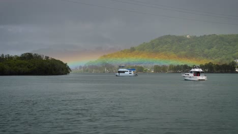 Rainbow-over-boats-moored-on-the-Tweed-River,-Northern-New-South-Wales,-Australia