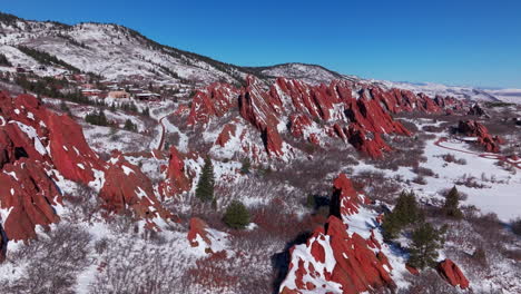 March-winter-morning-after-snowfall-stunning-Roxborough-State-Park-Colorado-aerial-drone-landscape-sharp-jagged-dramatic-red-rock-formations-Denver-foothills-front-range-hike-blue-sky-backward-motion