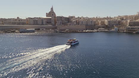 An-aerial-view-of-the-Malta-Sliema-to-Valletta-ferry,-on-a-sunny-morning,-making-its-way-to-Valletta-harbour
