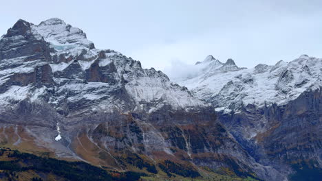 Grindelwald-mountain-glacier-peaks-valley-view-Switzerland-Swiss-Alps-snowy-Jungfrau-Junfrangu-Lauterbrunnen-October-cloudy-autumn-evening-landscape-top-of-gondola-ride-static-shot