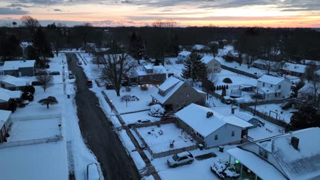 Aerial-birds-eye-over-snowy-housing-area-in-USA-at-golden-hour