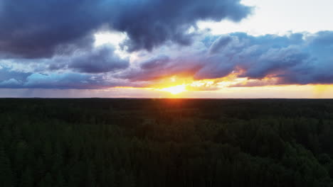 Aerial-view-of-a-stunning-summer-sunset-with-clouds-above-Nordic-woodlands