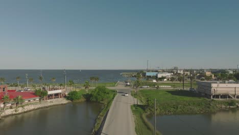 An-aerial-establishing-shot-zooms-out-from-the-Seabrook-Waterfront-welcome-sign-in-late-afternoon-in-Seabrook,-Texas