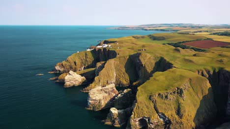 Aerial-Reveal-of-St-Abbs-Head's-Majestic-Cliffs-and-Lighthouse,-Scotland,-United-Kingdom