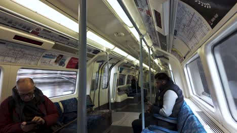 POV-View-Of-Commuters-Inside-Jubilee-Line-Train-Heading-North-In-London,-England,-UK