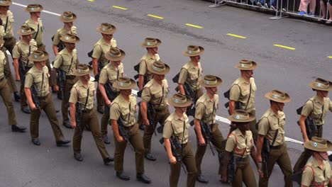 Bewaffnete-Australische-Armeetruppen-Der-Australischen-Verteidigungsstreitkräfte-Marschieren-In-Uniform-Die-Straße-Entlang-Und-Nehmen-An-Der-Jährlichen-Paradetradition-Teil,-Inmitten-Der-Feierlichkeiten-Zum-Anzac-Day-Gedenktag
