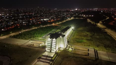 Concrete-memorial-honoring-Christopher-Columbus-illuminated-at-nigh,-aerial-arc