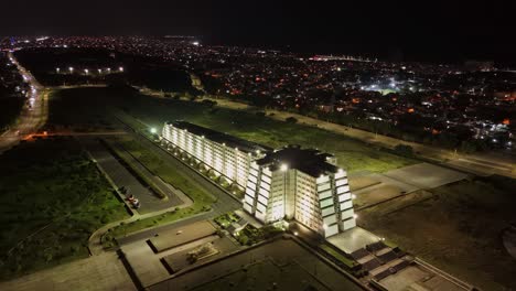 Concrete-mausoleum-of-Christopher-Columbus-lit-up-at-night,-aerial-arc