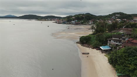 Imagen-Aérea-Que-Captura-Un-Pueblo-De-Pescadores-En-La-Costa-Brasileña,-Con-Vistas-A-La-Vasta-Extensión-Del-Océano-Atlántico.