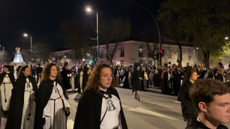 The-faithful-go-with-candles-in-rows,-one-on-each-side-of-the-procession,-in-the-middle,-the-women-in-black-with-combs,-the-acolytes-with-the-censers,-and-the-carried-virgin-continues-the-night