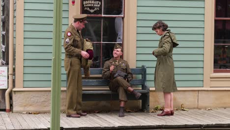 Recreación-De-Soldados-De-La-Segunda-Guerra-Mundial-Y-Uso-De-Chat-Femenino-Frente-A-Una-Barbería-En-Ohio-Village-En-Ohio-Connection-En-Columbus,-Ohio