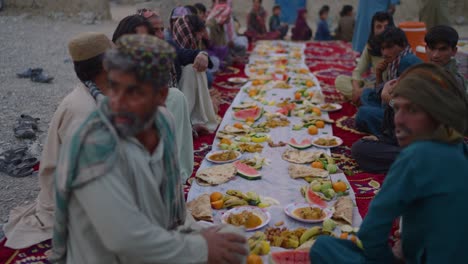 Einheimische-Sitzen-Draußen-Neben-Essen-Während-Der-Ramadan-Iftar-Fahrt-In-Khuzdar-Belutschistan