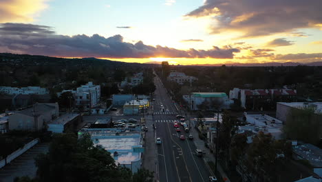 Aerial-view-of-a-tow-truck,-picking-up-a-car-in-the-suburbs-of-LA,-sunset-in-USA