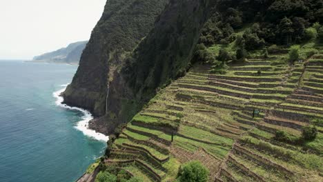 Stunning-aerial-view-across-Madeira-Véu-da-Noiva-viewpoint-terraced-coastal-mountain-seascape-slopes