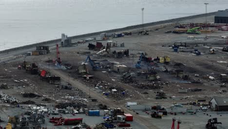 Heavy-equipment-works-at-the-scrap-yard,-which-cuts-and-demolishes-scrap-metal-located-in-the-port-area