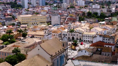 Aerial-view-of-Terreiro-de-Jesus-square-close-to-Pelourinho-with-colorful-buildings-and-the-sea-at-background,-Salvador,-Bahia,-Brazil