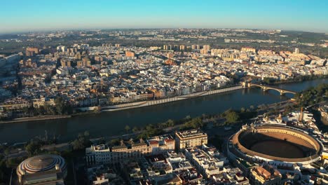 Aerial-panoramic-drone-of-Guadalquivir-navigable-river-in-Cordoba-Spain-Town-City-streets-neighborhood-and-daylight-skyline