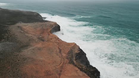 Drone-shot-of-ocean-water-hitting-the-shoreline-of-Cape-Bridgewater-in-Australia