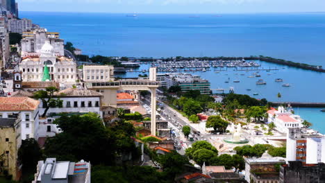 Aerial-view-of-Elevador-Lacerda,-the-city-around-and-the-sea-at-the-background,-Salvador,-Bahia,-Brazil