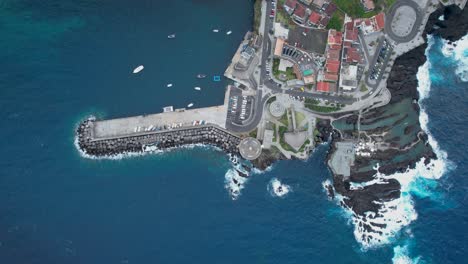 Stunning-Porto-Montiz-aerial-view-looking-down-at-natural-turquoise-coastal-pools-of-the-Madeira-waterfront-resort