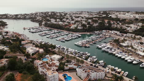 Aerial-view-of-Cala-d'Or-marina-with-moored-boats-and-white-buildings