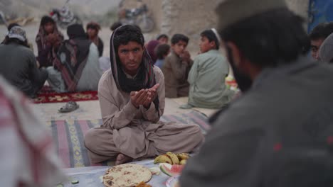 Young-Muslim-Male-Praying-before-having-iftar-dinner-together-during-ramadan-in-Khuzdar,-Balochistan