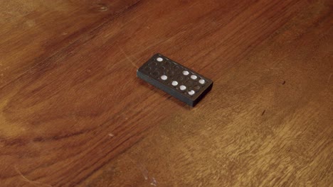 Game-play:-close-up-view-of-domino-tiles-placed-onto-wooden-table-top