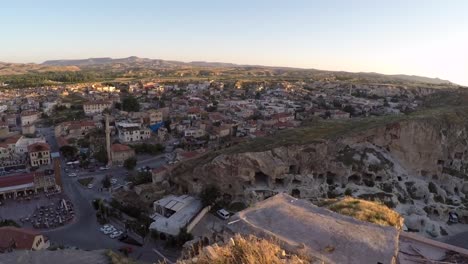 Aerial-reveal-of-a-Turkish-town-in-cappadocia-with-foreground-of-a-ruin