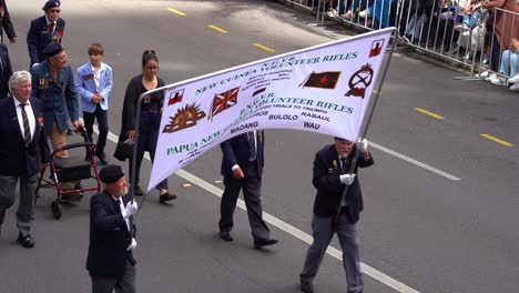 Veterans-and-families-from-the-Papua-New-Guinea-Volunteer-Rifles-unit-walking-down-the-street,-participating-the-annual-Anzac-Day-parade-tradition-at-Brisbane-city