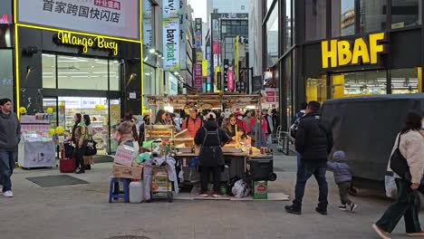Crowd-of-Tourists-Buy-Street-Food-in-Stalls-at-Myeongdong-Market-in-Seoul
