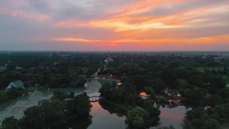 Ein-Farbenfroher-Sonnenuntergang-über-Einem-Riesigen-Grünen-Park-Mit-Wasserstraßen-Am-Stadtrand-Von-Ayutthaya,-Thailand
