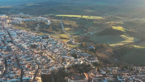 Ciudad-Panorámica-De-Ronda-España-Pueblo-Histórico-Morisco-En-Málaga-Destino-Turístico-Europeo,-Arquitectura-Morisca,-Sol-Sobre-Campos-Verdes