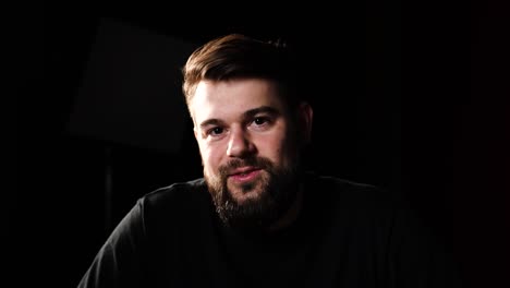 Talking-head-shot-of-male-in-studio-type-setting-with-black-background