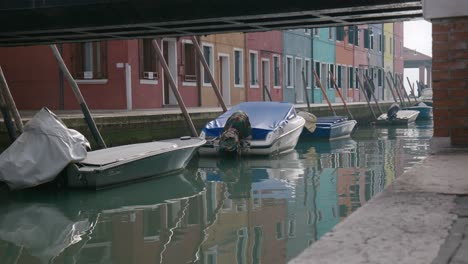 Canal-view-with-moored-boats-in-Burano,-Venice-Italy