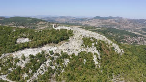 Drone-panning-from-the-left-to-the-right-side-of-the-frame-in-front-of-a-hill-where-the-ancient-city-of-Perperikon-is-located,-Rin-the-province-of-Kardzhali,-in-Bulgaria