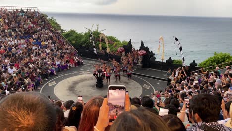 A-large-crowd-of-tourists-watch-a-Kecak-dance-performance-at-Uluwatu-Temple,-Bali,-Indonesia