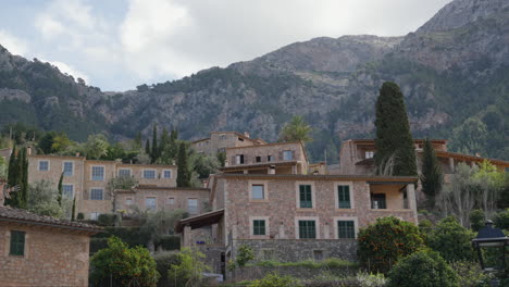 Traditional-stone-houses-of-Deia,-Mallorca-beneath-mountain-backdrop