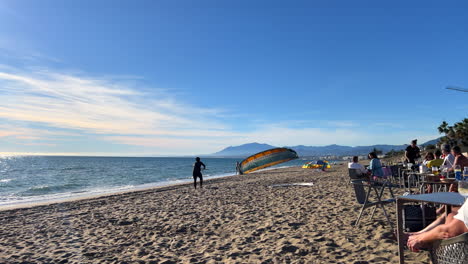 Ein-Kitesurfer-Am-Strand-Von-Marbella-An-Einem-Windigen,-Sonnigen-Tag-Mit-Blauem-Himmel,-Kiteboarding,-Kitesurfen-In-Spanien,-4k-Aufnahme