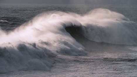 Ola-Gigante-En-Nazaré-Rompiendo-Con-Un-Rocío-Dramático-Con-Luz-Dorada-En-Cámara-Lenta-De-4k