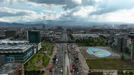 Vista-Aérea-Hacia-Atrás-Sobre-El-Tráfico-En-La-Avenida-NQS-En-La-Nublada-Bogotá,-Colombia