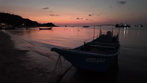 Bei-Sonnenuntergang-Zieren-Ruhige-Fischerboote-Die-Küste-Von-Koh-Tao,-Thailand,-Während-Die-Abendsonne-Ihre-Goldenen-Strahlen-Auf-Das-Schimmernde-Wasser-Wirft-Und-Die-Essenz-Von-Reisen-Und-Urlaub-Verkörpert